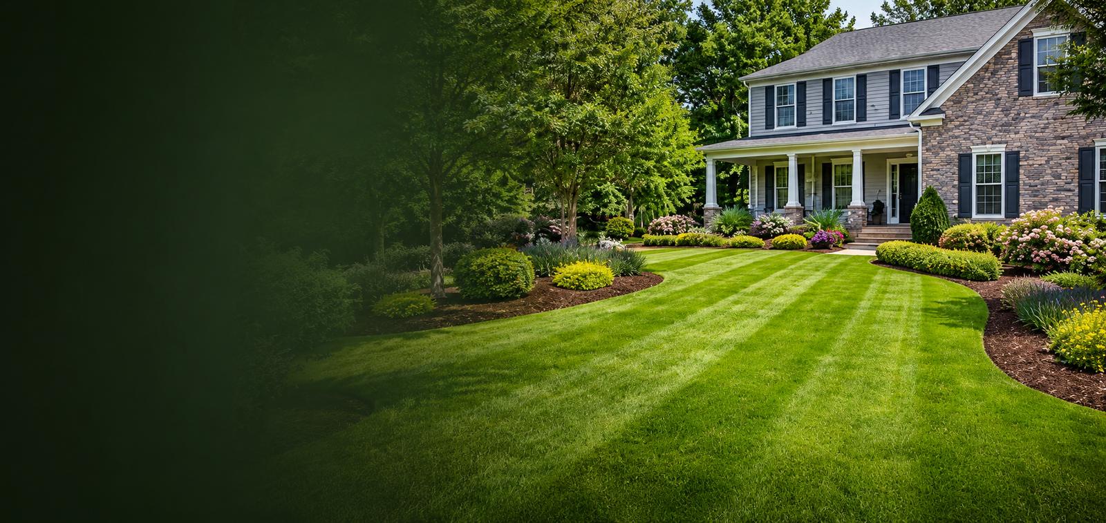 Freshly mowed, striped lawn with manicured flower beds in front of a two-story Metro Atlanta home